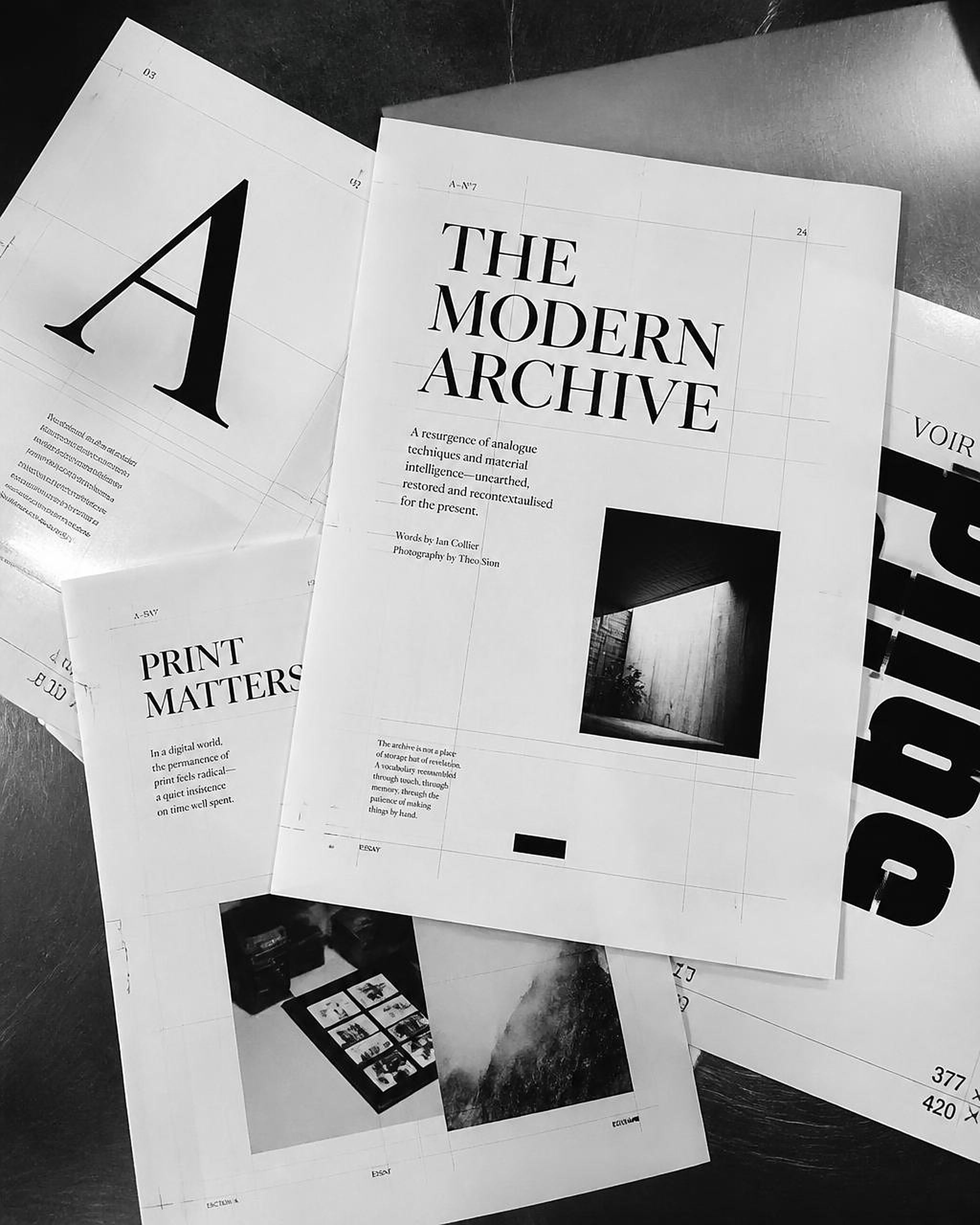 Black and white editorial print layouts on a studio table